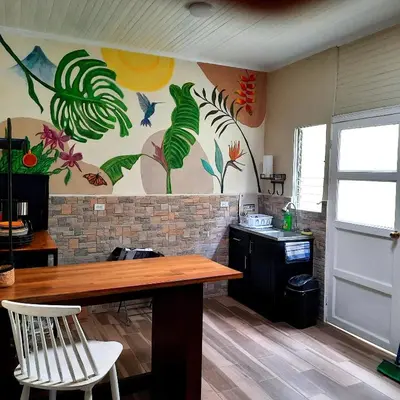 a kitchen with a table and a painting on the wall at 2 Room 1 ba close to SJO airport, Poás and waterfalls in Alajuela City