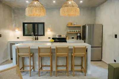 a kitchen with a large island with bar chairs at Manuel Antonio Tree House Villas - 3 Bedrooms in Quepos