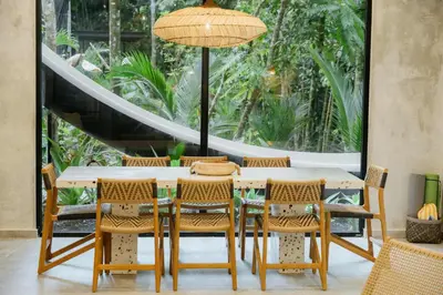 a dining room with a table and chairs and a large window at Manuel Antonio Tree House Villas - 3 Bedrooms in Quepos