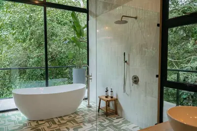 a bathroom with a tub and a shower and a sink at Manuel Antonio Tree House Villas - 3 Bedrooms in Quepos