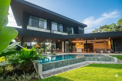 a house with a swimming pool in front of it at Xanadu Arenal Villa in Fortuna
