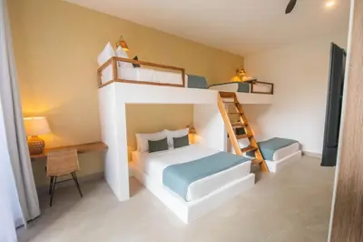 a bedroom with a bunk bed and a ladder at Xanadu Arenal Villa in Fortuna