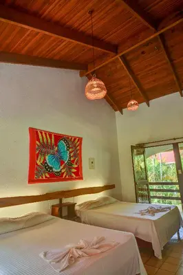 a bedroom with two beds and a painting on the wall at Hotel Pochote Grande in Jacó