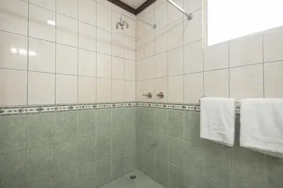 a bathroom with a shower with white towels at Casa del Sol - Poolside Villa in Quepos