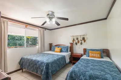 a bedroom with two beds and a ceiling fan at Casa del Sol - Poolside Villa in Quepos