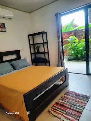 a bedroom with a bed and a sliding glass door at Moon Home Sand #2 in Playa hermosa