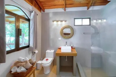 a bathroom with a toilet and a sink and a mirror at Casa Mariposa in Esterillos