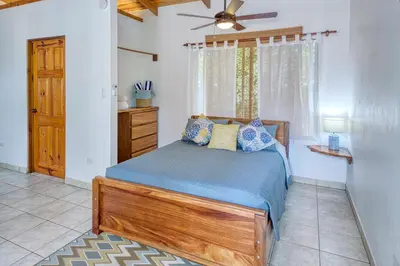 a bedroom with a bed and a ceiling fan at Casa Mariposa in Esterillos