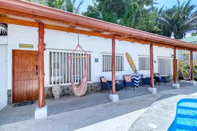 a pavilion with chairs and surfboards on a patio at Casa Mariposa in Esterillos