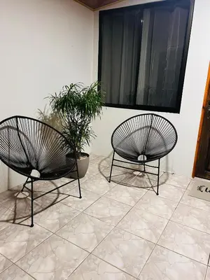 two black chairs and a plant in a room at Arenal Harmony-Acogedor Apartamento-La Fortuna in Fortuna