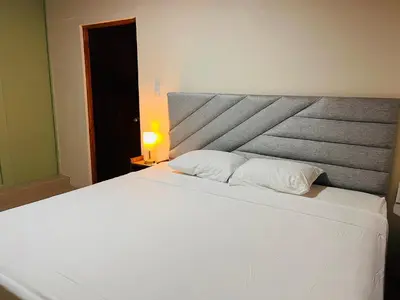 a bedroom with a large white bed with a headboard at Arenal Harmony-Acogedor Apartamento-La Fortuna in Fortuna