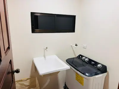 a bathroom with a sink and a tv on the wall at Arenal Harmony-Acogedor Apartamento-La Fortuna in Fortuna