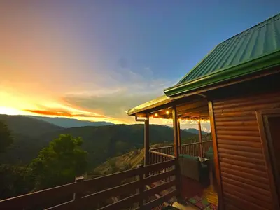 a house with a deck with a view of the mountains at Cabaña Nora in Cedral