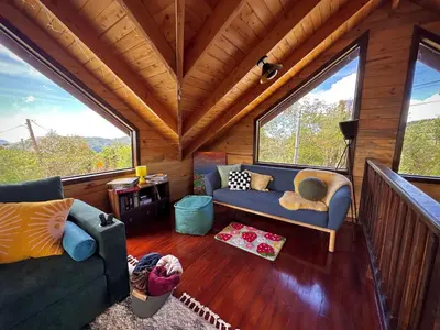 a living room with two couches and large windows at Cabaña Nora in Cedral