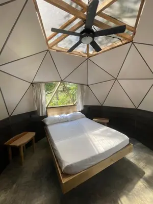 a bed in a room with a ceiling fan at La Selva in Hojancha