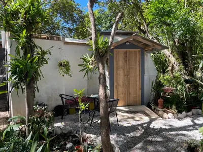 a small house with a table and a wooden door at La Selva in Hojancha