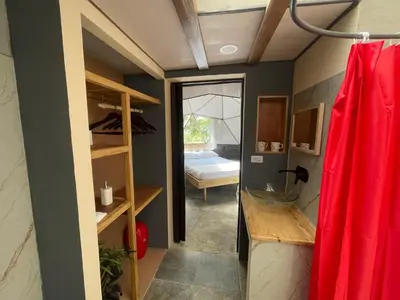 a bathroom with a red shower curtain and a bedroom at La Selva in Hojancha