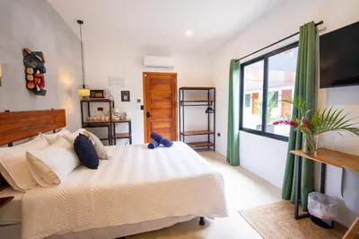 a bedroom with a large bed and a window at Bahia Selvatica Lodge in Uvita