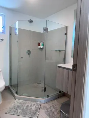 a glass shower in a bathroom with a sink at 16th Floor Oceanview Bliss in Jacó