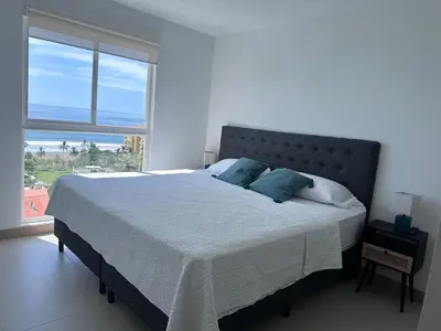 a bedroom with a bed with a view of the ocean at 16th Floor Oceanview Bliss in Jacó