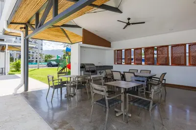 a dining room with tables and chairs and a grill at 16th Floor Oceanview Bliss in Jacó
