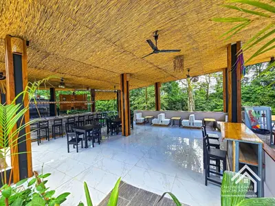 an outdoor patio with tables and chairs and a ceiling at La Granja Boutique Nature Luxury and Relaxation in Guayabal
