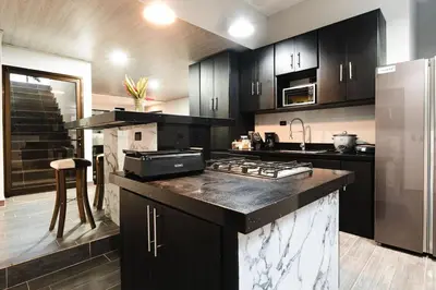 a kitchen with black cabinets and a stove top oven at La Granja Boutique Nature Luxury and Relaxation in Guayabal