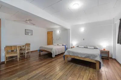 a room with two beds and a table in it at Hotel el Tajalin in Montezuma