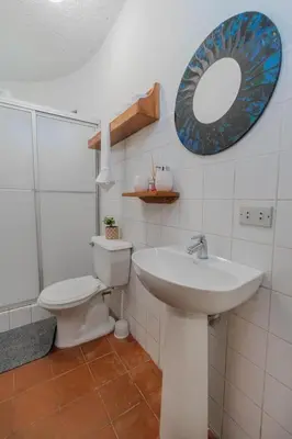 a bathroom with a sink and a toilet and a mirror at Hotel el Tajalin in Montezuma