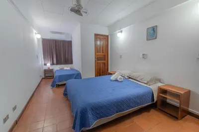 a bedroom with two beds and a window at Hotel el Tajalin in Montezuma
