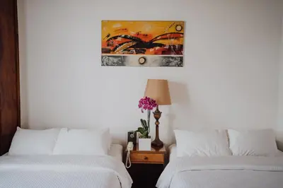 a bedroom with two beds and a painting on the wall at Hotel Dunn Inn in San José
