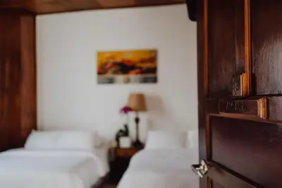 a bedroom with two beds and a wooden door at Hotel Dunn Inn in San José