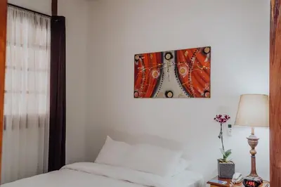 a bedroom with a bed and a picture on the wall at Hotel Dunn Inn in San José