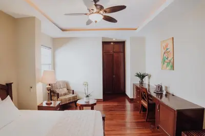 a bedroom with a bed and a ceiling fan at Hotel Dunn Inn in San José