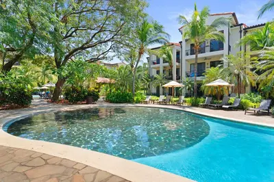 a swimming pool in front of a hotel at Condo with Pool Tennis Pickleball in Ocotal