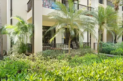 a building with palm trees in front of it at Condo with Pool Tennis Pickleball in Ocotal