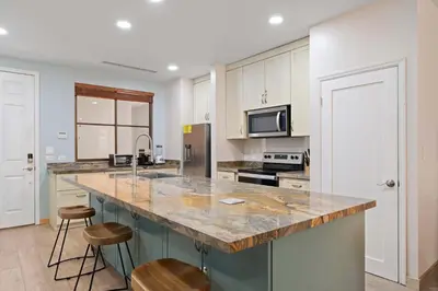 a kitchen with a large island with two stools at Condo with Pool Tennis Pickleball in Ocotal