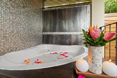 a bath tub with flowers and candles in a bathroom at Villa Buena Onda All Inclusive in Coco