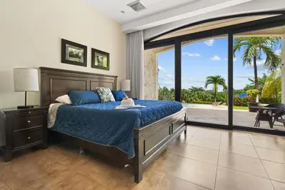 a bedroom with a bed and a large window at Villa Buena Onda All Inclusive in Coco