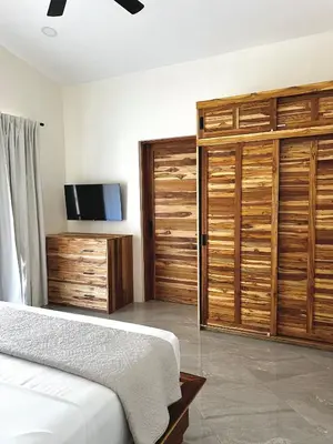 a bedroom with wooden cabinets and a bed and a tv at Casa María - Playa hermosa Cóbano in Playa hermosa