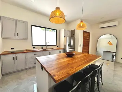 a kitchen with a wooden table and chairs in it at Casa María - Playa hermosa Cóbano in Playa hermosa