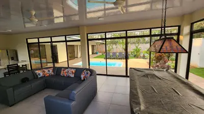 a living room with a blue couch and a pool at Casa Mar Azul in Quepos