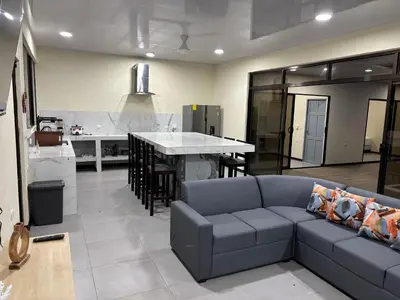 a living room with a couch and a kitchen at Casa Mar Azul in Quepos