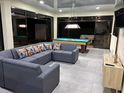 a living room with a couch and a pool table at Casa Mar Azul in Quepos