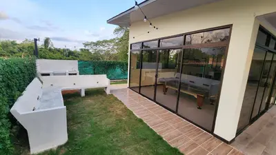 a house with a bench and a table in the yard at Casa Mar Azul in Quepos