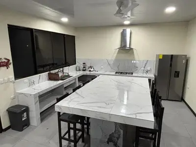 a kitchen with white marble counter tops and a kitchen island at Casa Mar Azul in Quepos