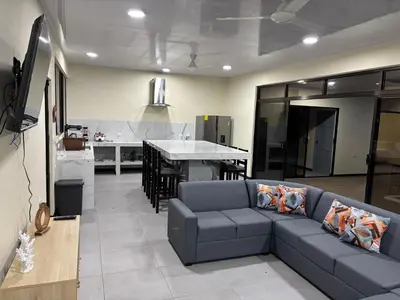a living room with a couch and a kitchen at Casa Mar Azul in Quepos
