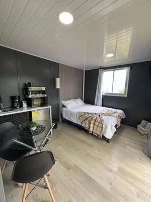 a bedroom with a bed and a desk and a chair at El Cedro Lodge in Alajuela City