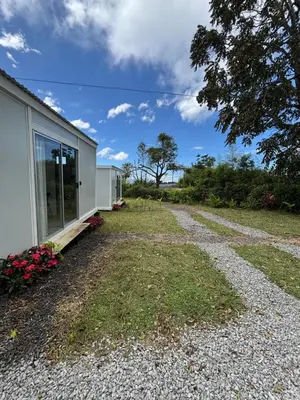 a house with a window and a gravel driveway at El Cedro Lodge in Alajuela City
