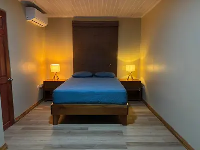 a bedroom with a bed with blue sheets and two lamps at The Social Fortuna in Fortuna